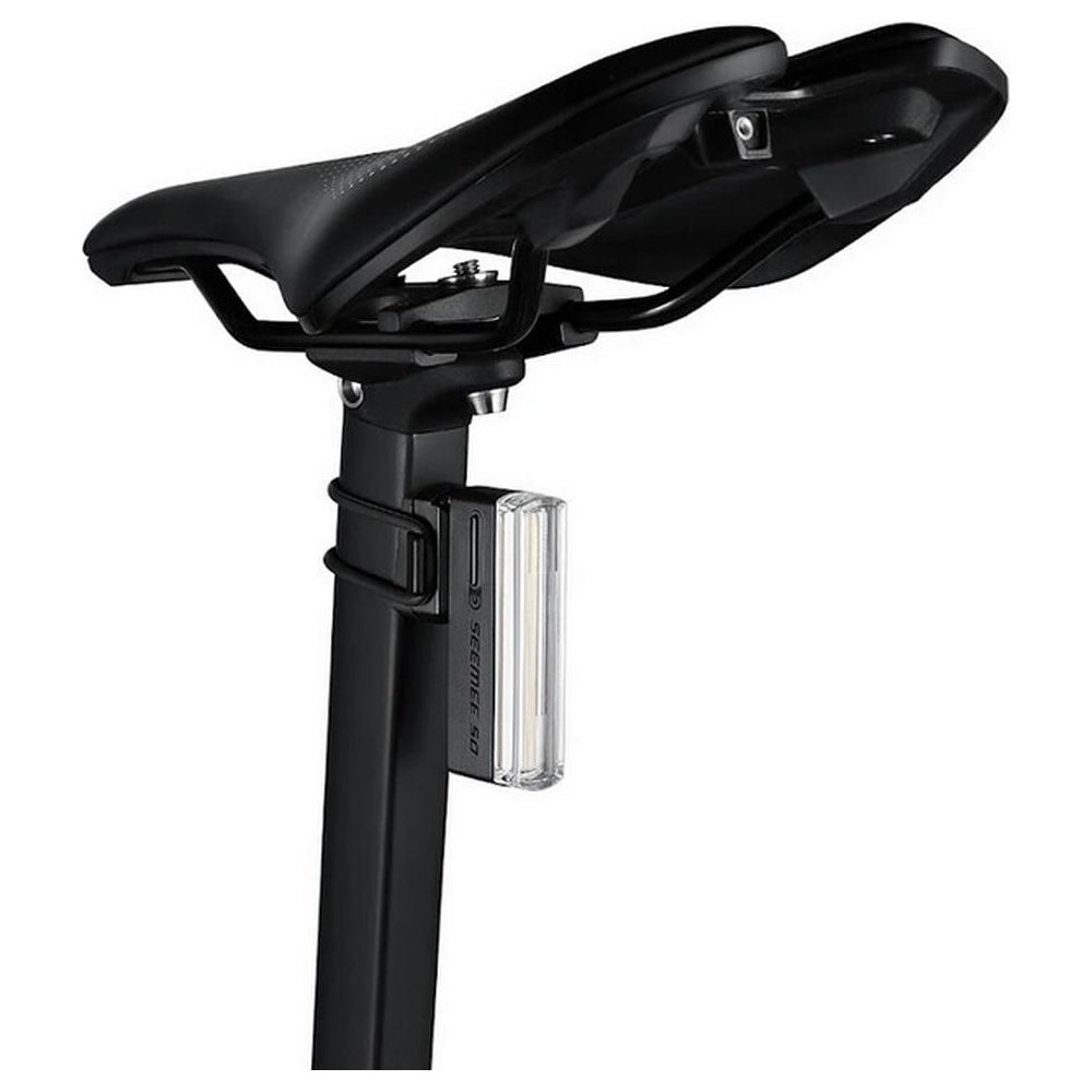 Ein schwarzer Fahrradsattel mit einer kleinen, transparenten Rückleuchte, die am Sattelgestell befestigt ist.