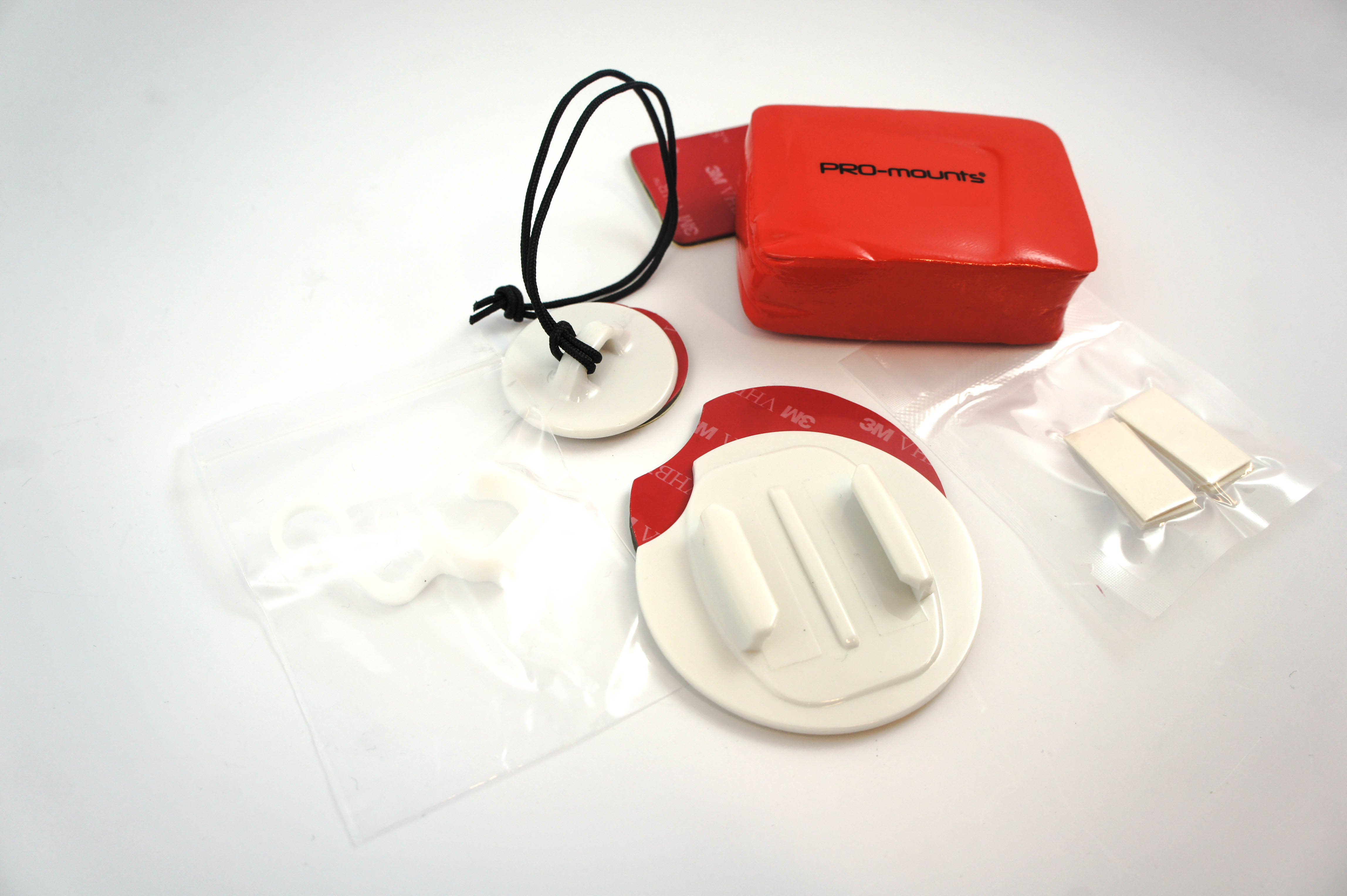 Ein rotes PRO-mounts Paket mit Halterungen, Klebestreifen und einem Lanyard.