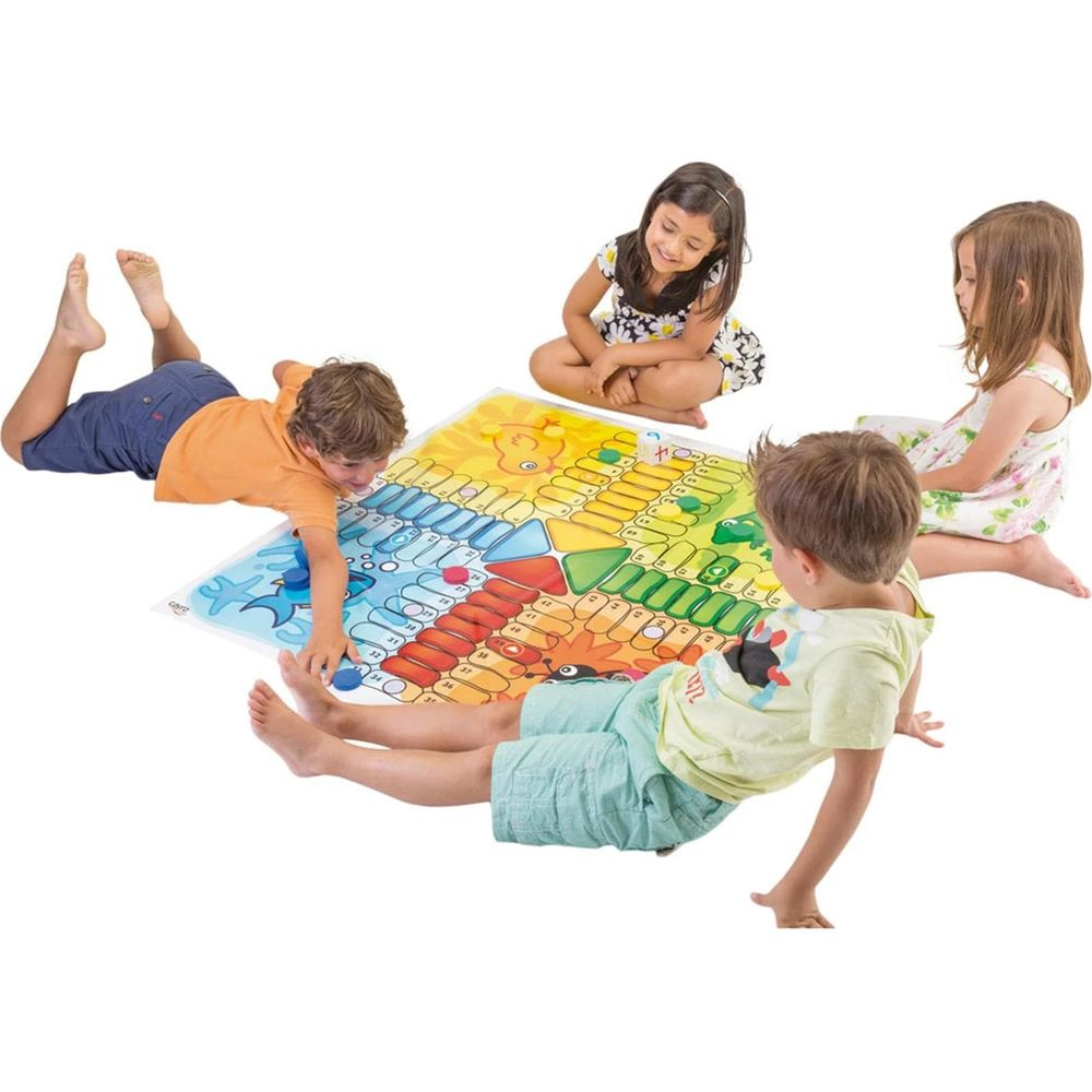 Cuatro niños jugando un colorido juego de mesa en el suelo.