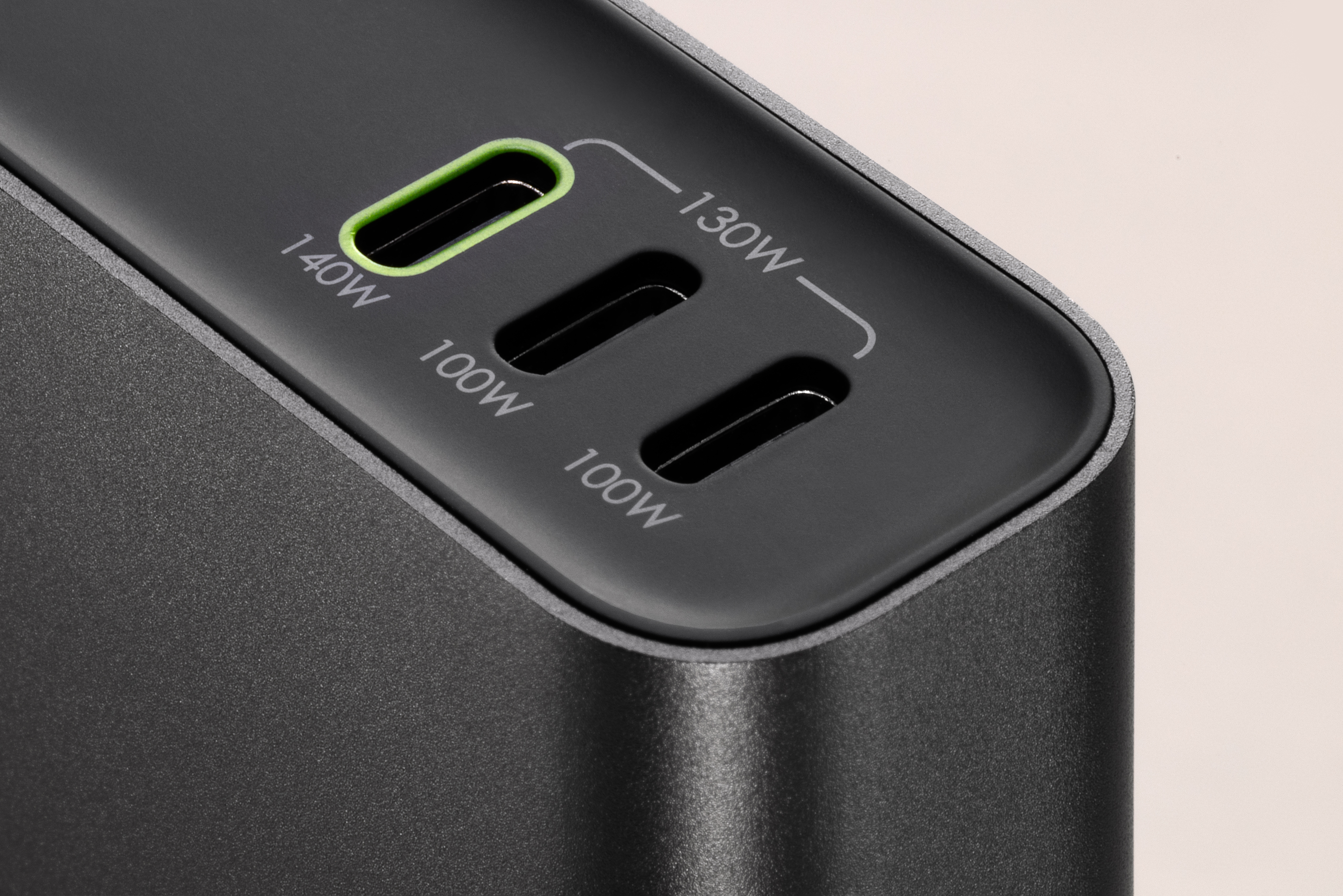 Primo piano di un caricabatterie nero con tre porte USB-C.