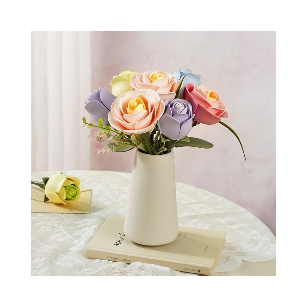 Ein cremefarbener Kerzenständer mit bunten Rosen auf einem Tisch.