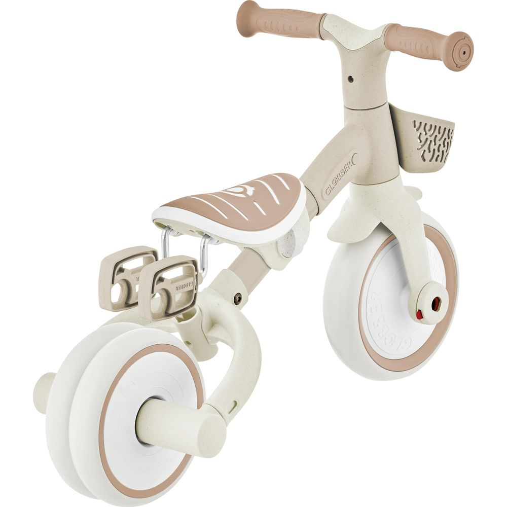 Ein beiger und brauner Dreirad-Roller mit Korb, Pedalen und einem gepolsterten Sitz.