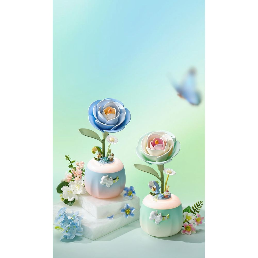 Zwei dekorative Blumenvasen mit stilisierten Blumen und Schmetterlingen, hellblau und grün.