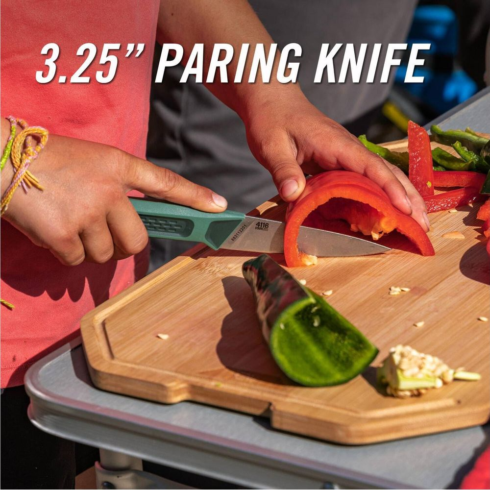 Eine Person schneidet mit einem Messer rote Paprika auf einem Holzbrett.