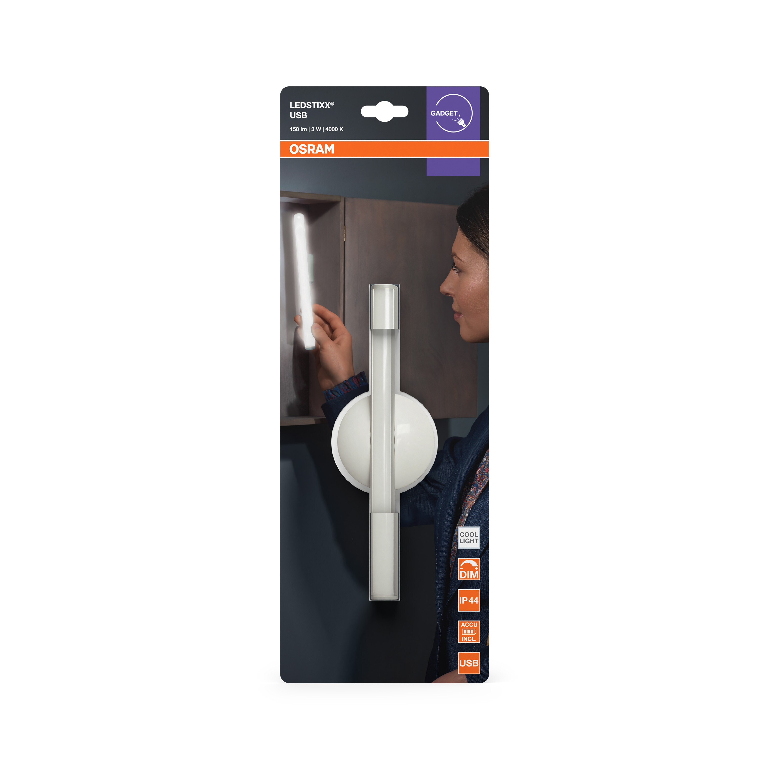 Eine Frau hält eine leuchtende OSRAM LEDSTIXX USB-Leuchte an eine dunkle Holzoberfläche.