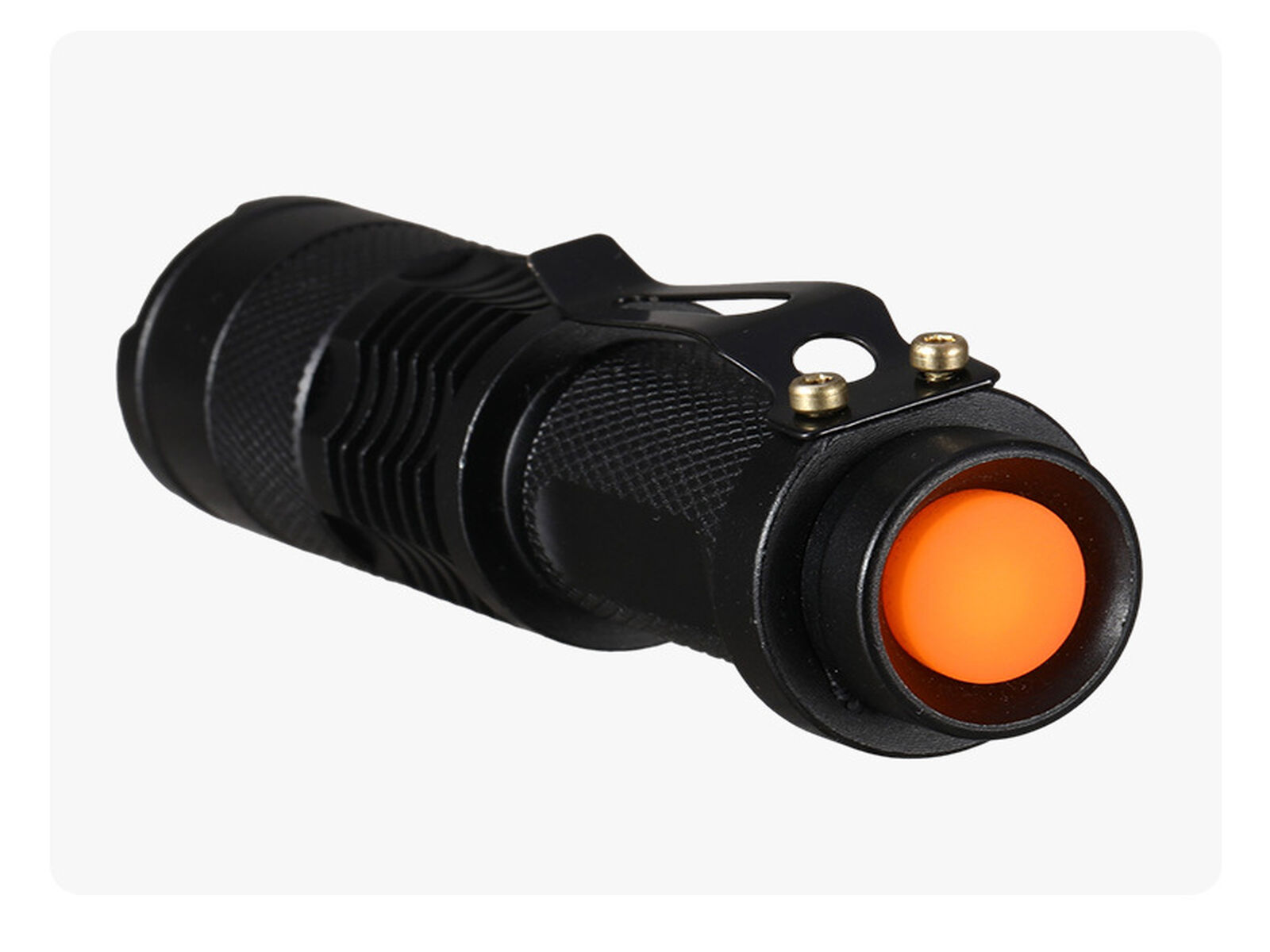 Eine schwarze Taschenlampe mit einem orangefarbenen Knopf und einem Clip, auf weißem Hintergrund.
