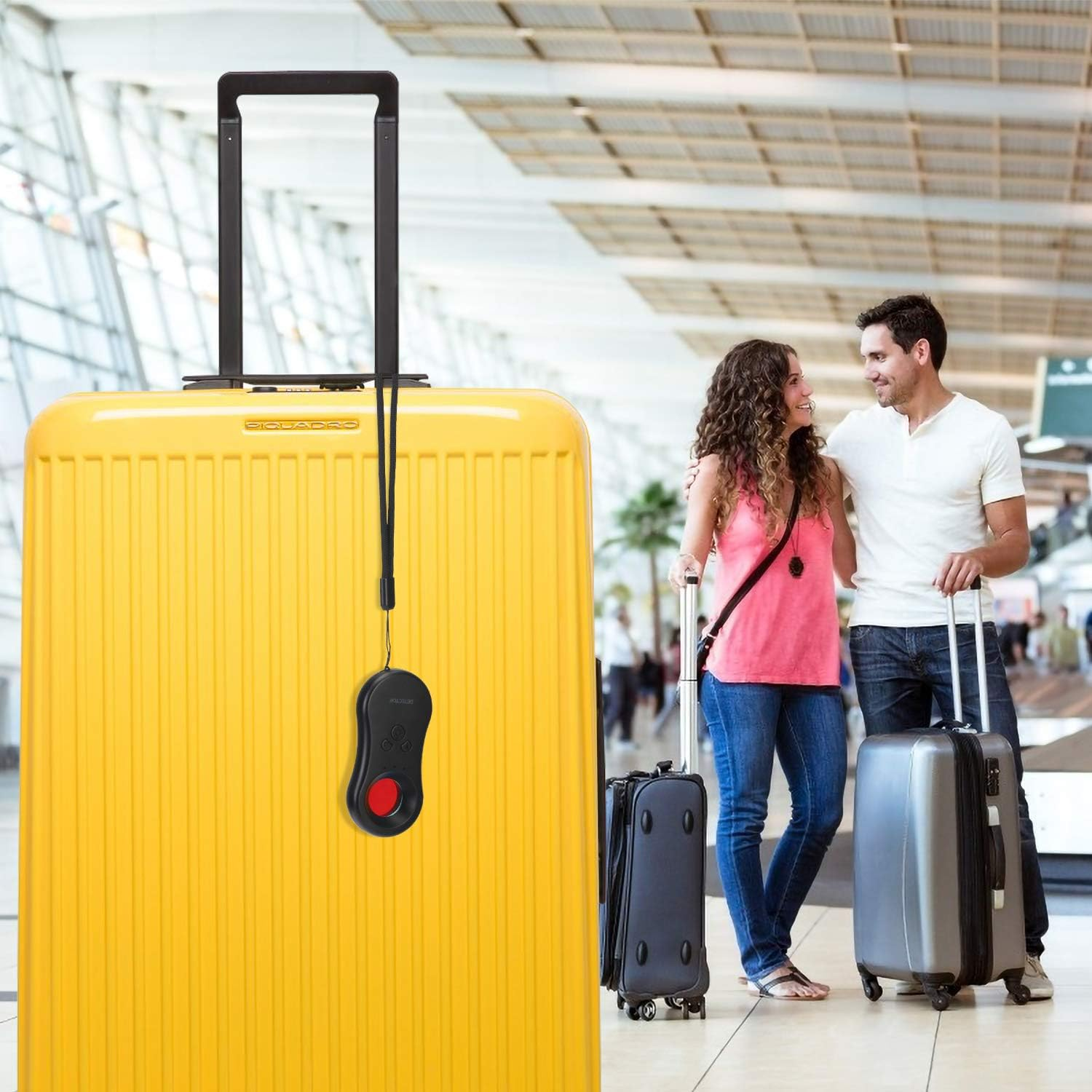 Ein Mann und eine Frau stehen mit Gepäck in einem Flughafen. Eine große gelbe Reisetasche ist vorne.