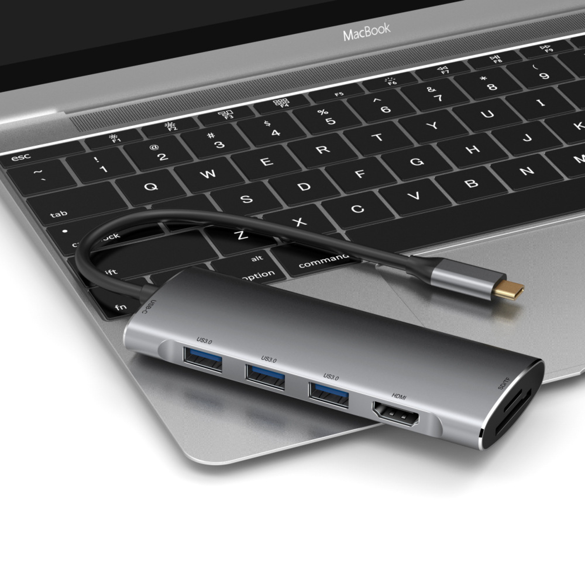 Ein silberner USB-C-Hub mit drei USB 3.0 Anschlüssen, HDMI und SD/TF-Kartensteckplätzen liegt auf einer MacBook-Tastatur.