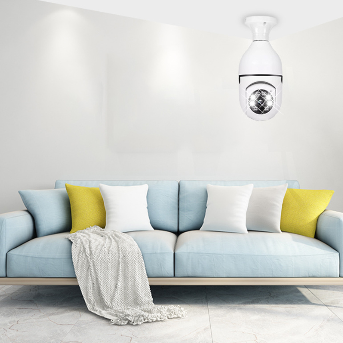 Eine weiße Überwachungskamera hängt von der Decke über einem hellblauen Sofa mit Kissen.