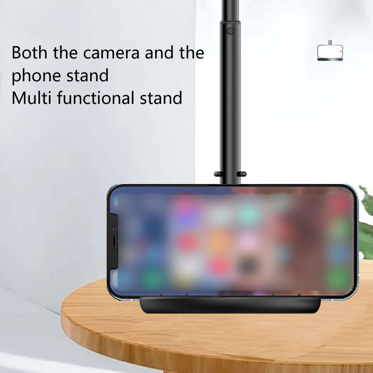 Ein Handy steht auf einem runden Holztisch, befestigt an einem schwarzen Ständer.