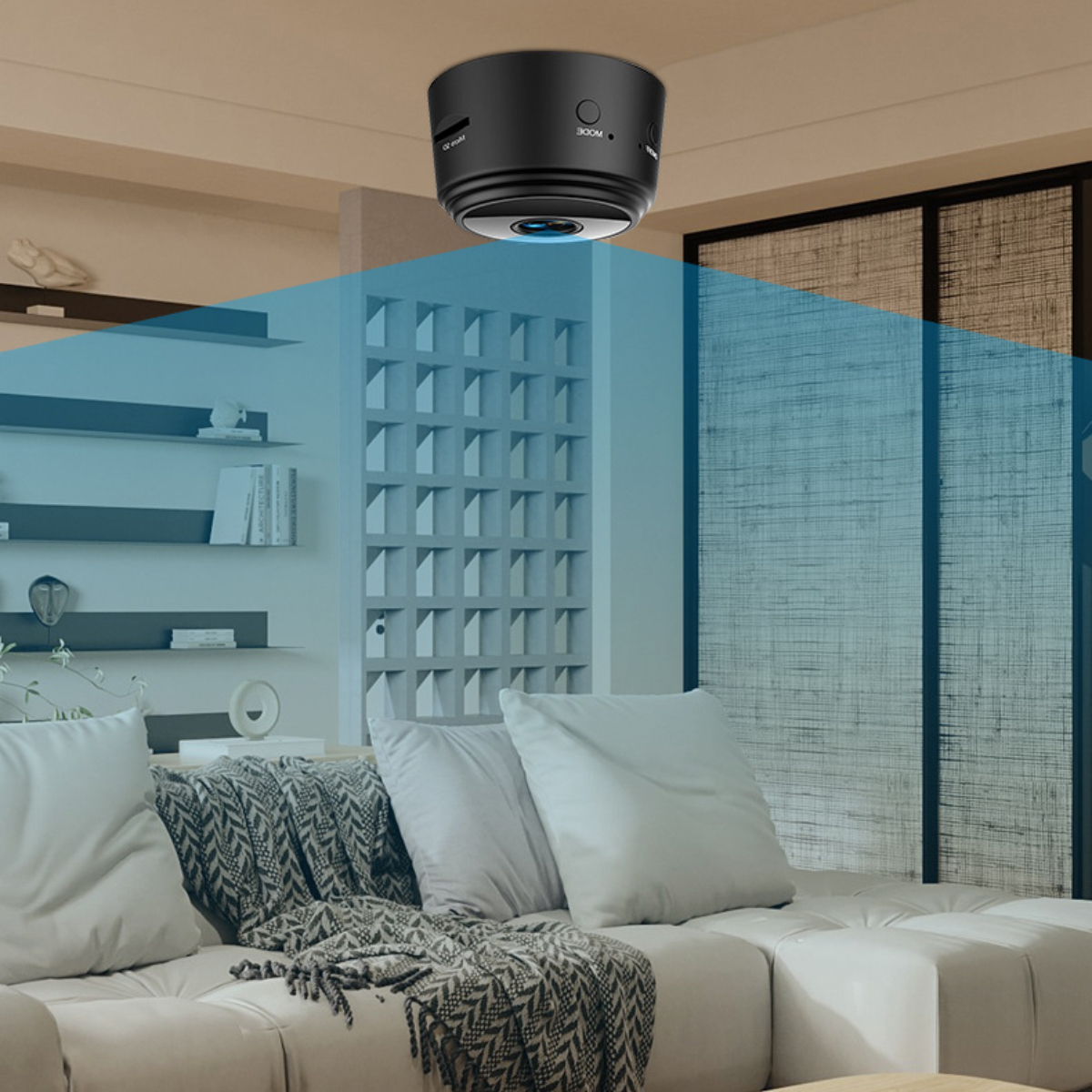 Eine schwarze Kamera ist an der Decke montiert und blickt auf ein weißes Sofa und Regale.