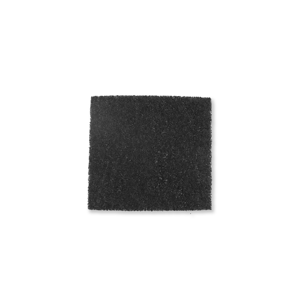 Un tampone di schiuma rettangolare scuro con texture ruvida, isolato su sfondo bianco.