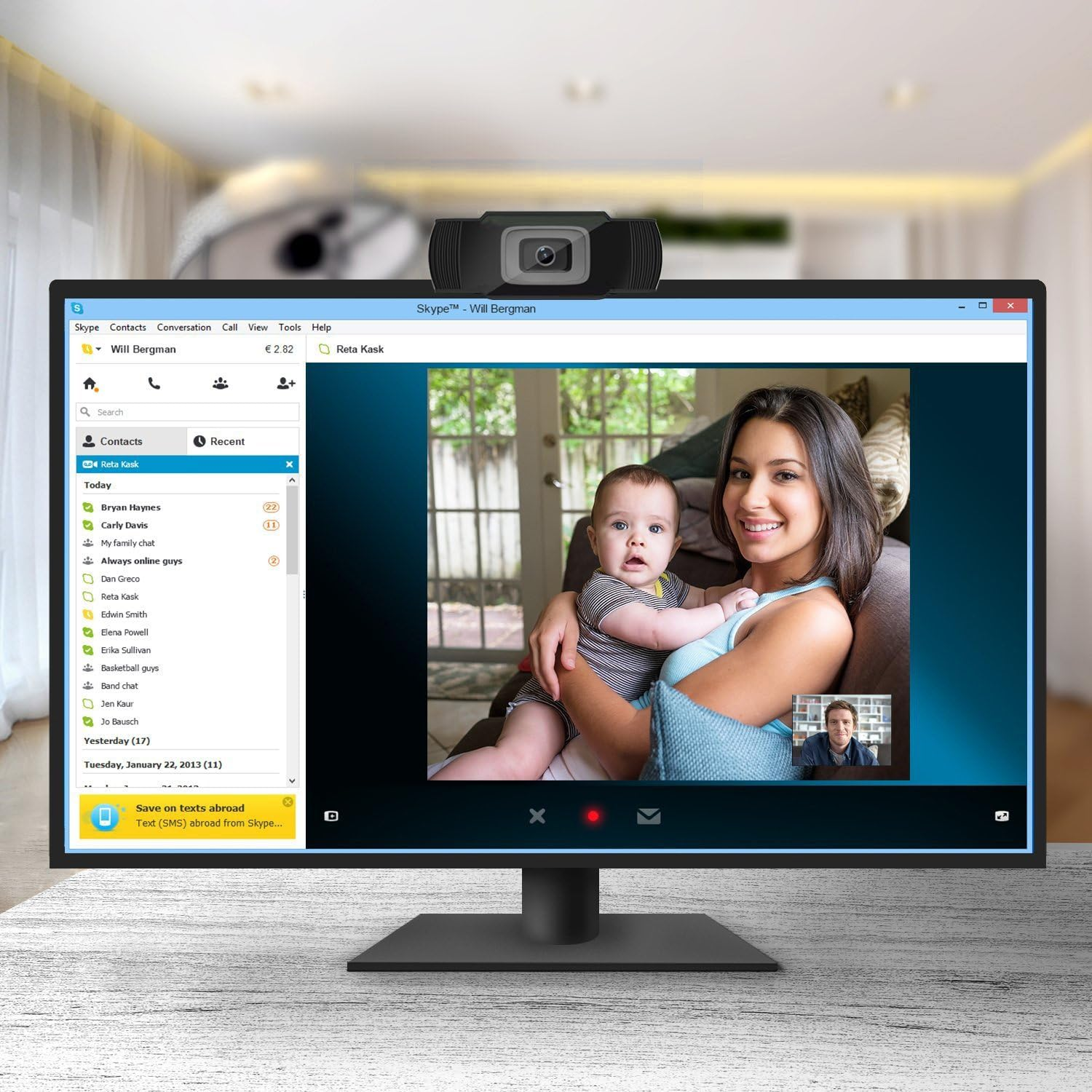 Ein Skype-Videoanruf zeigt eine Frau, die ein Baby hält, und einen kleinen Bildschirm mit einem Mann.