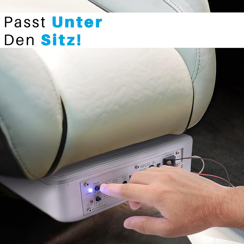 Ein Mann passt einen Verstärker unter einen Autositz. Der Verstärker ist silberfarben.