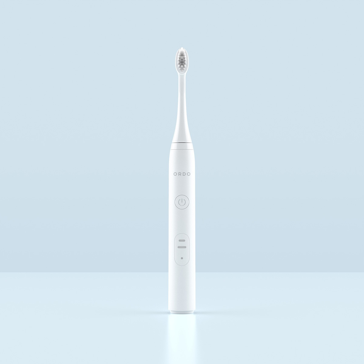 Un cepillo de dientes eléctrico blanco con cerdas grises sobre fondo azul.