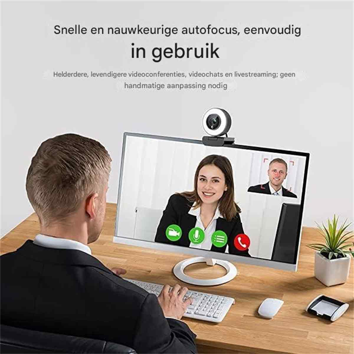 Mann bei Videokonferenz mit Webcam und zwei Personen auf dem Bildschirm.