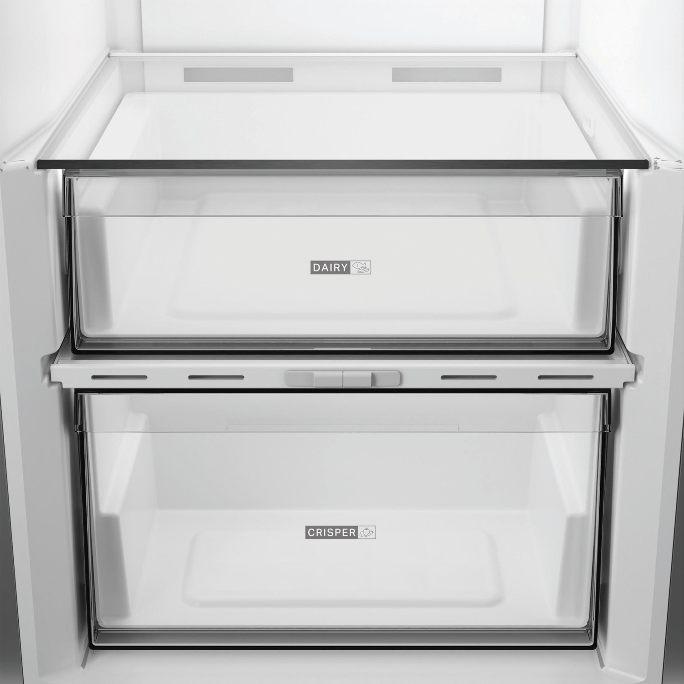 Lege koelkastinterieur met een zuivellade en een groentelade.