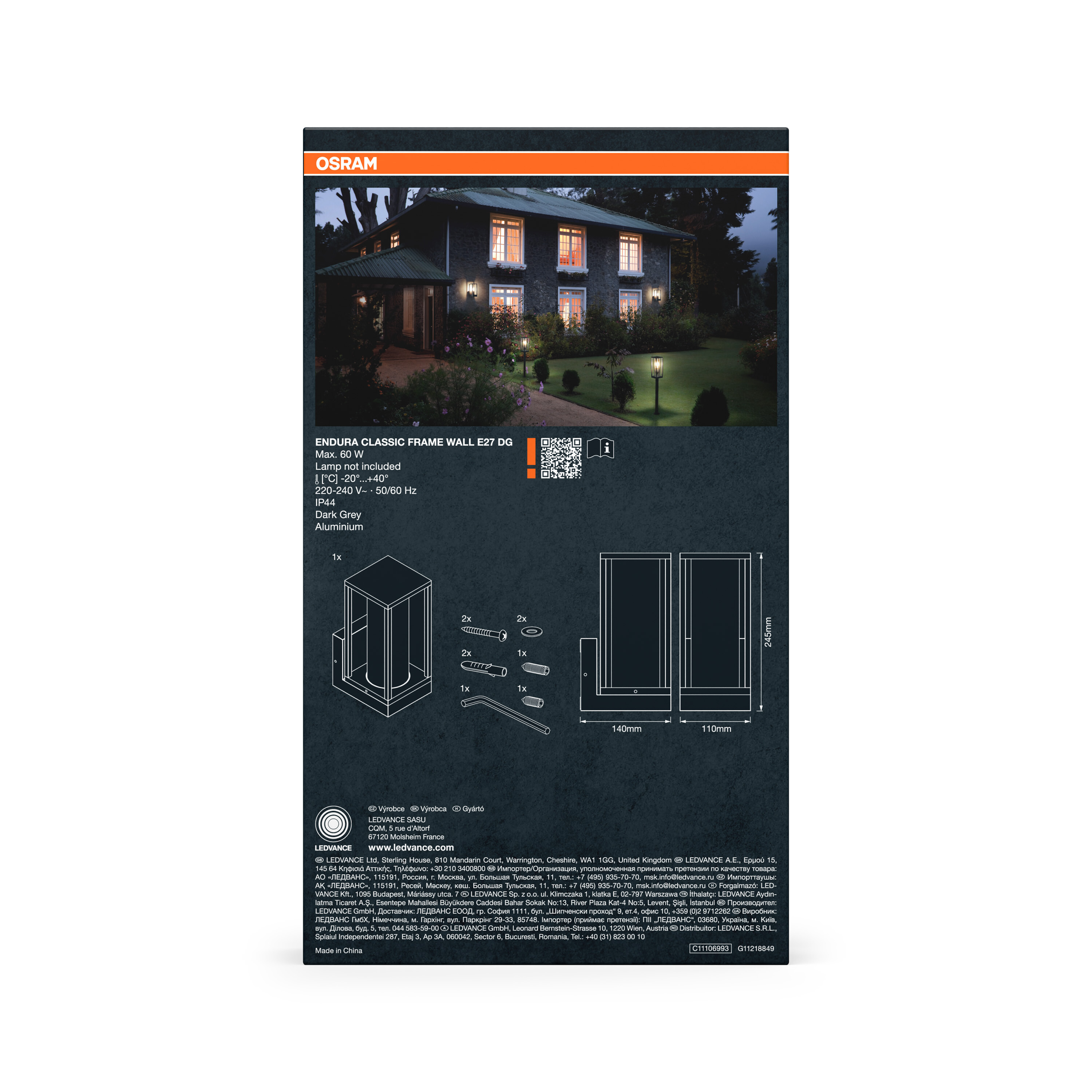 Ein dunkles Haus mit beleuchteten Fenstern und Gartenlaternen bei Nacht.
