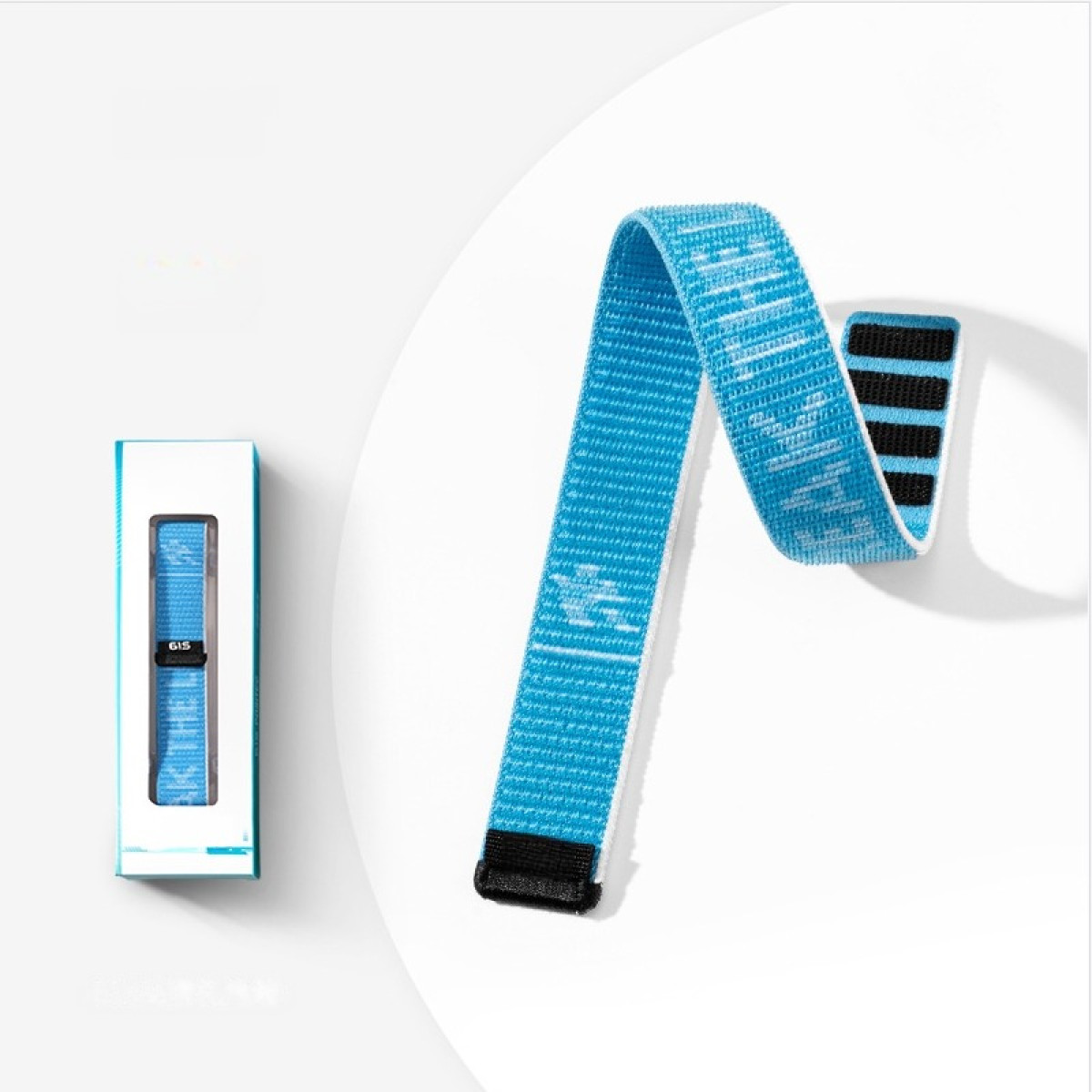 Ein blaues Band mit schwarzem Klettverschluss liegt neben einer Verpackung.