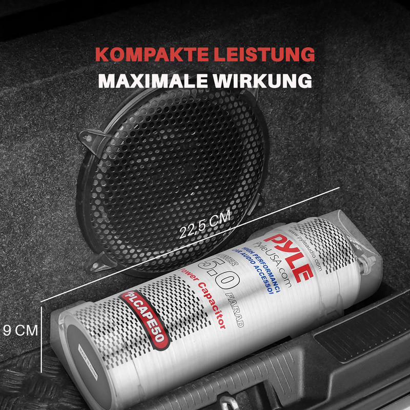 Ein Pyle 5.0 Farad Kondensator neben einem schwarzen Lautsprechergitter in einem Kofferraum.