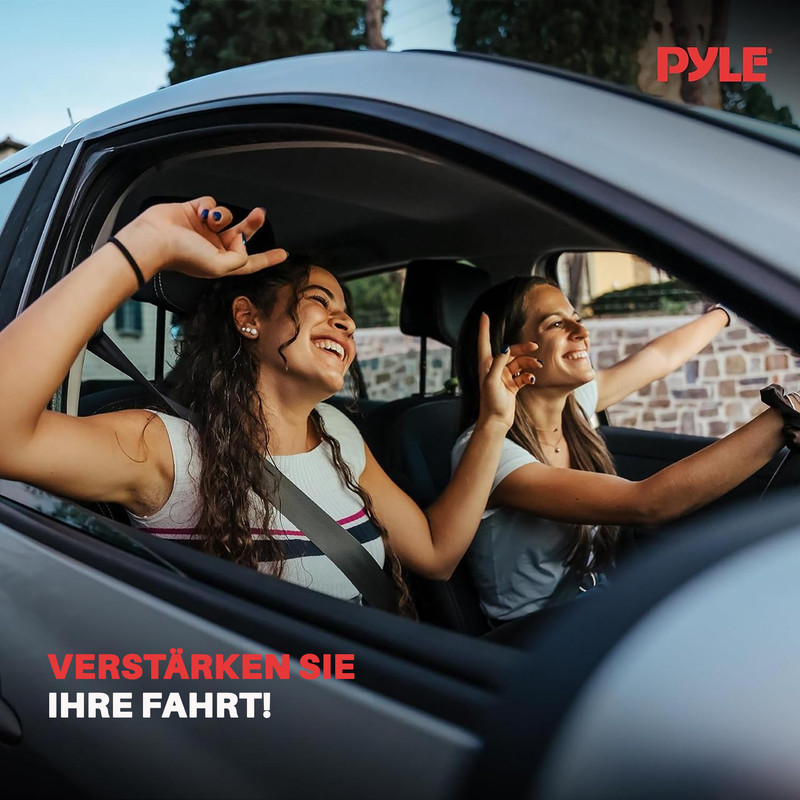 Zwei junge Frauen fahren lachend im Auto, die Hände zum Himmel gestreckt.