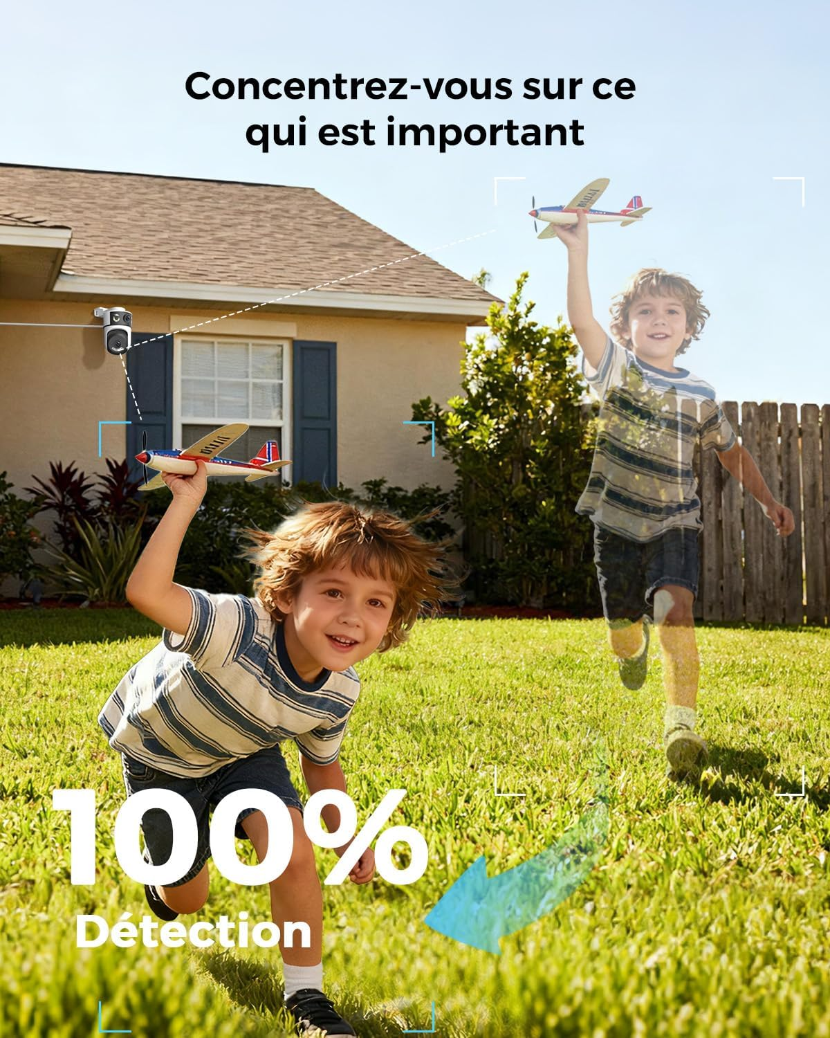 Zwei Jungen spielen mit Flugzeugspielzeug im Garten vor einem Haus.