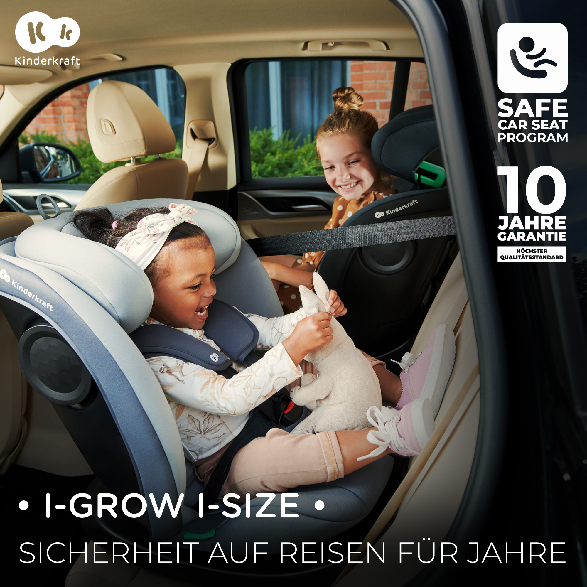 Zwei kleine Mädchen in einem Autositz. Das vordere Kind hält ein Plüschtier.