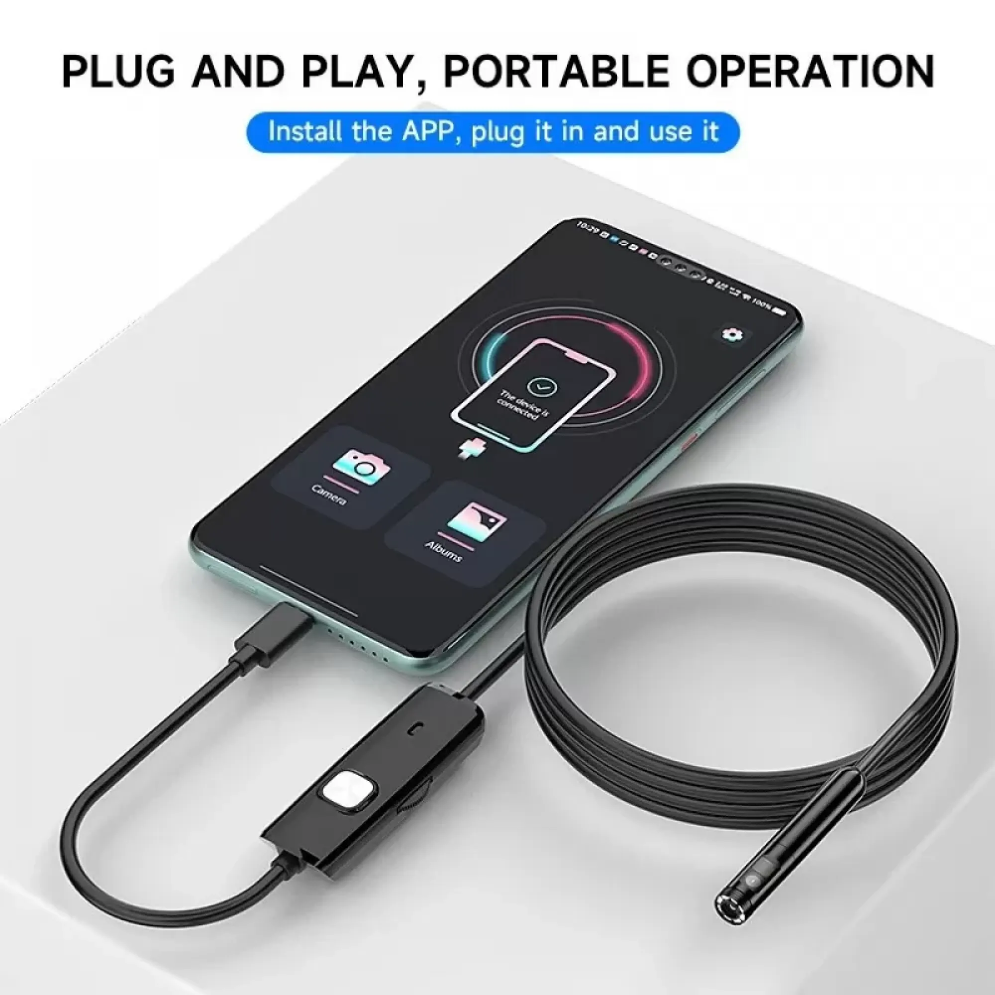 Ein Smartphone zeigt die App mit angeschlossenem Gerät; daneben liegt ein schwarzes Kabel.