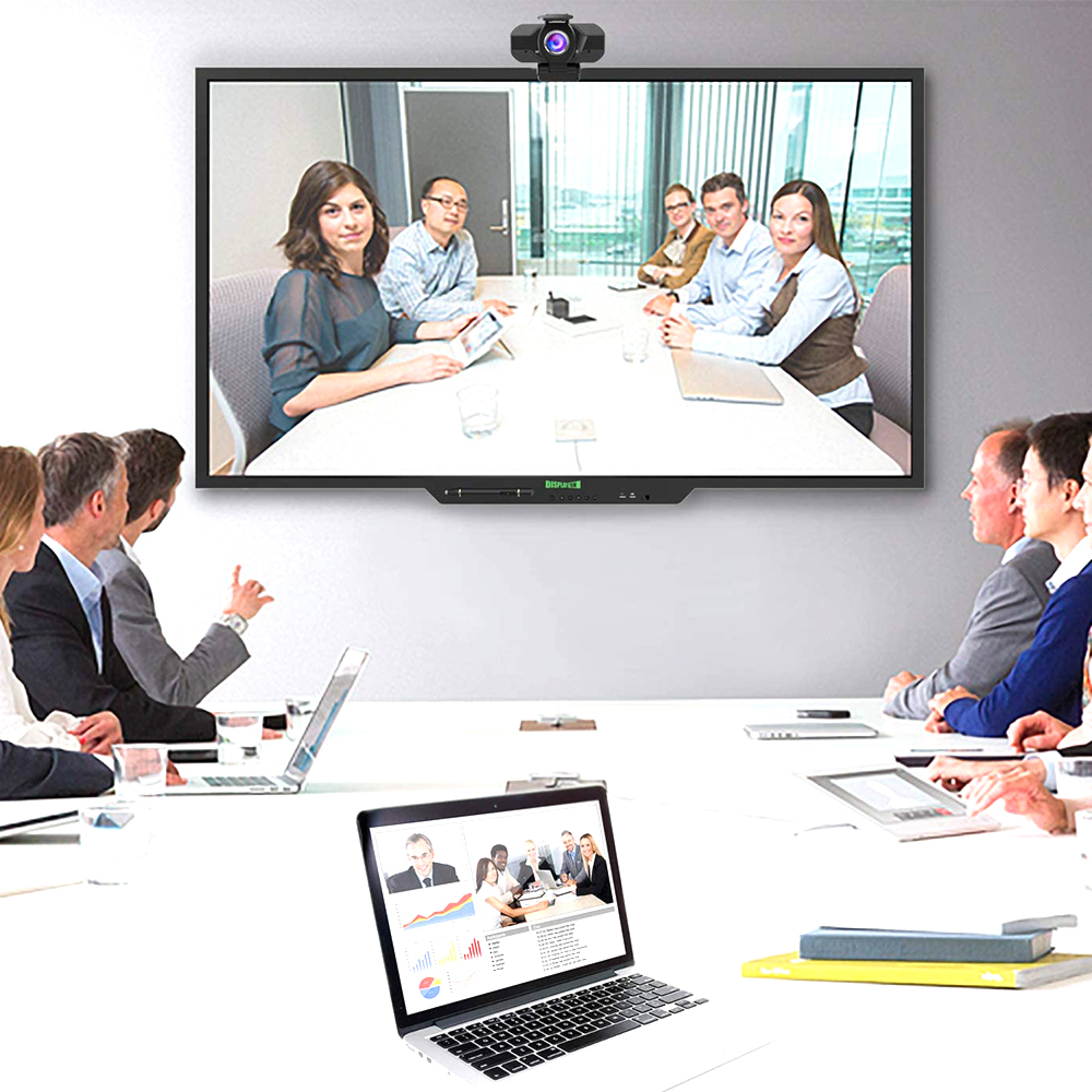 Ein Konferenzraum mit einer großen Leinwand, die ein Videokonferenzgespräch zeigt.
