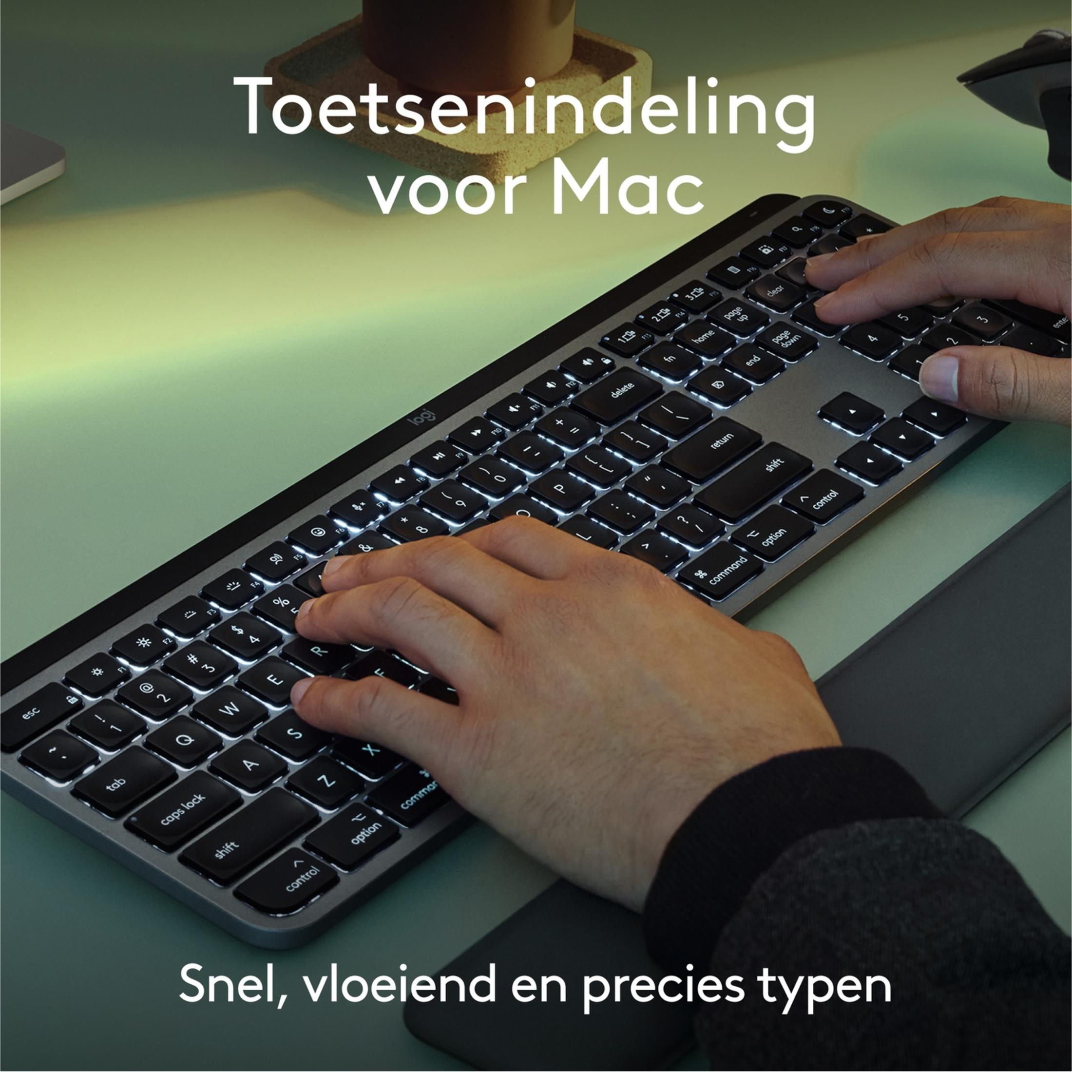 Hände tippen auf einer beleuchteten Mac-Tastatur mit niederländischer Beschriftung.