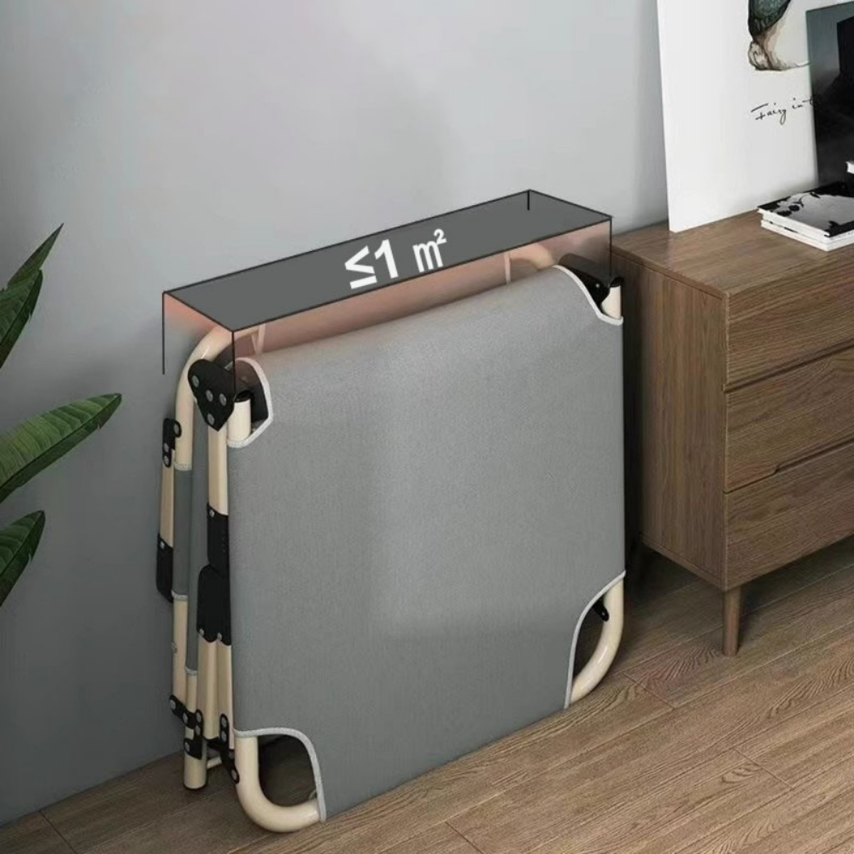 Ein graues, zusammenklappbares Feldbett steht an einer Wand neben einem Nachttisch.