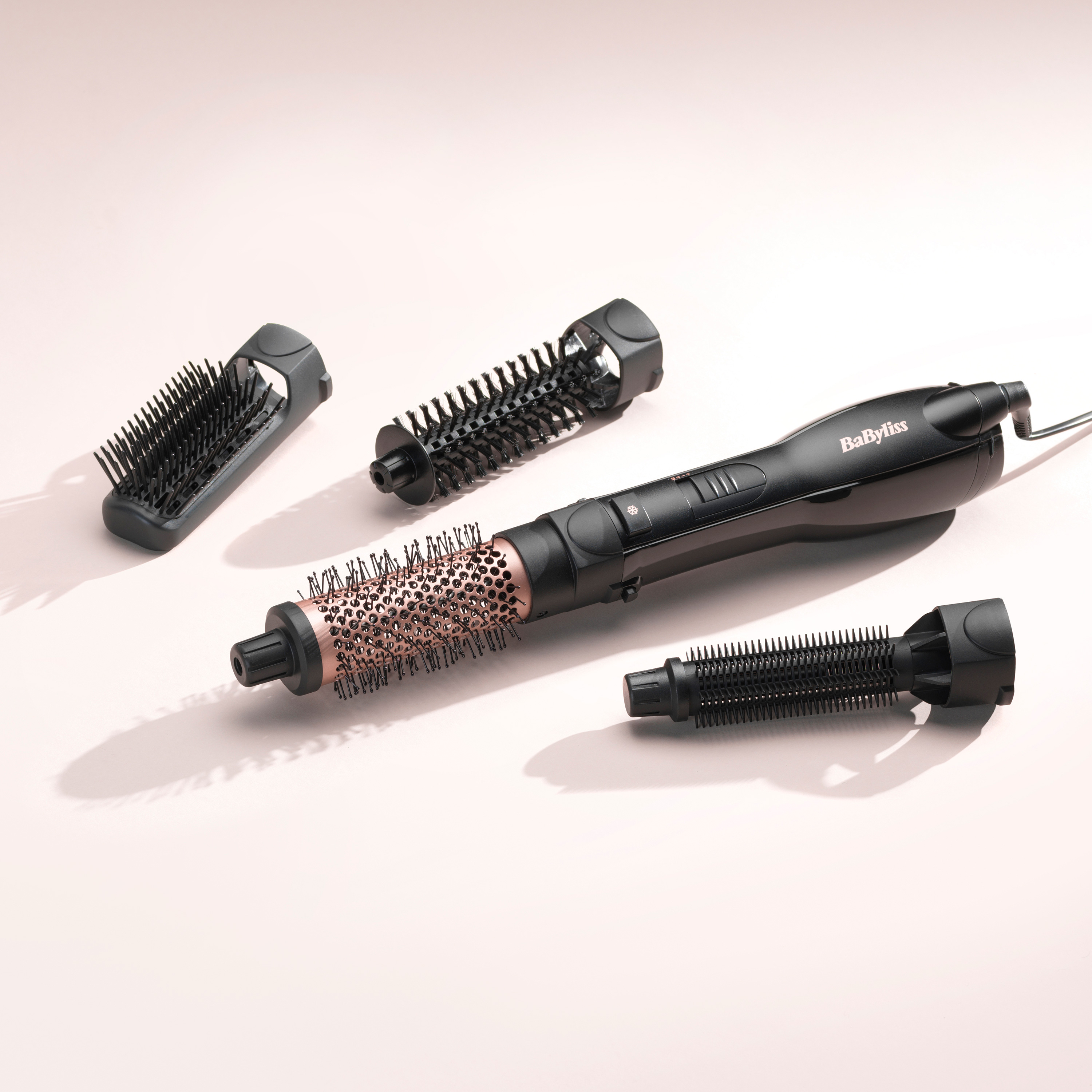 Ein schwarzes Babyliss Haartrockner-Set mit vier Aufsätzen auf hellem Untergrund.