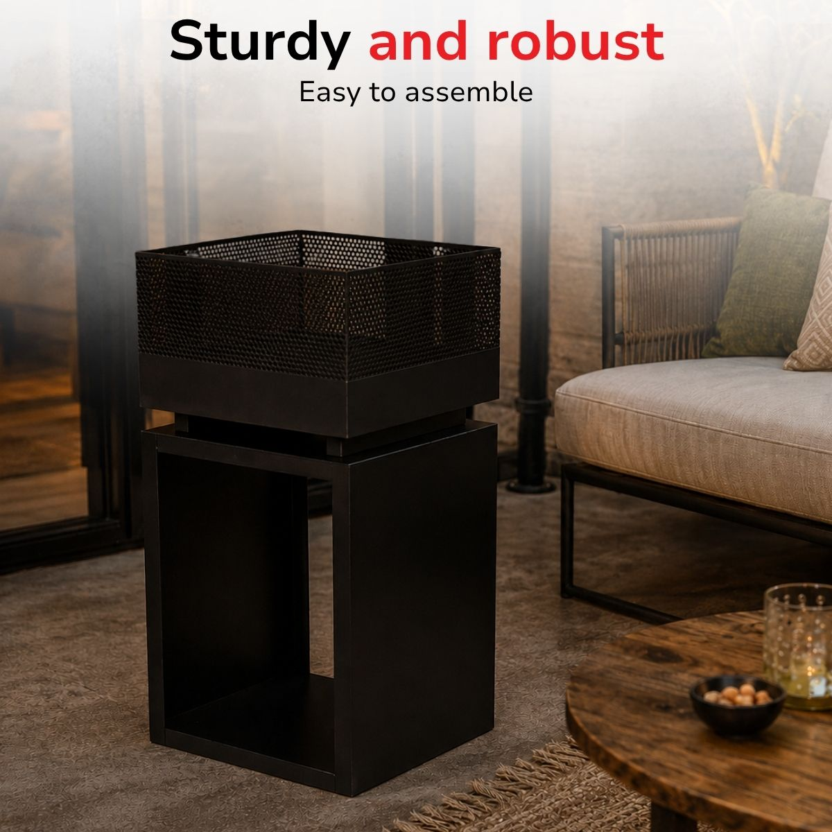 A black metal basket sits on a black stand, next to a sofa and coffee table.