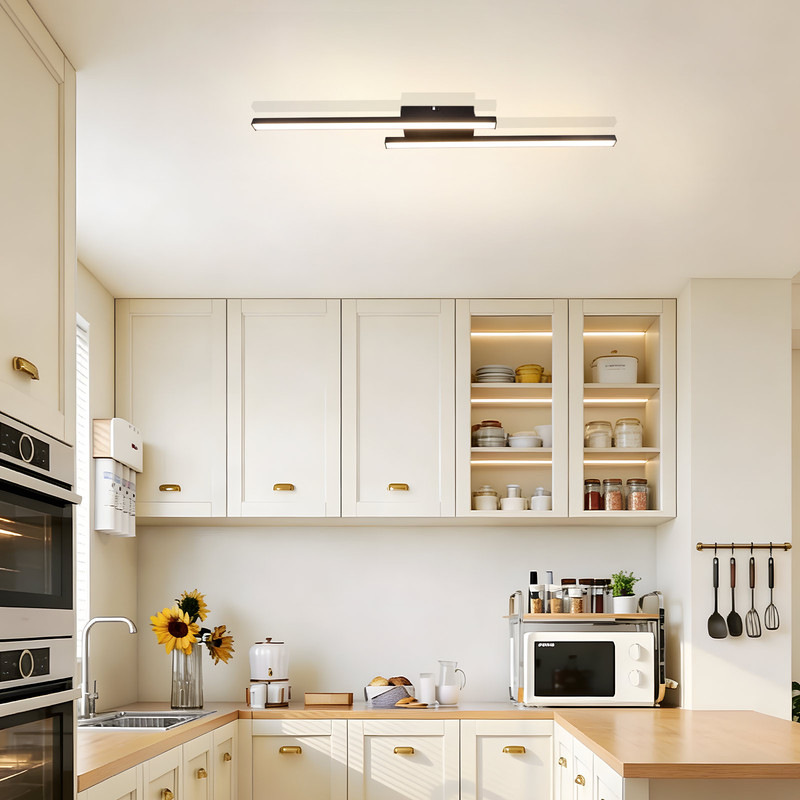 Moderne Küche mit cremefarbenen Schränken, Geräten aus Edelstahl und einer eleganten Deckenleuchte.
