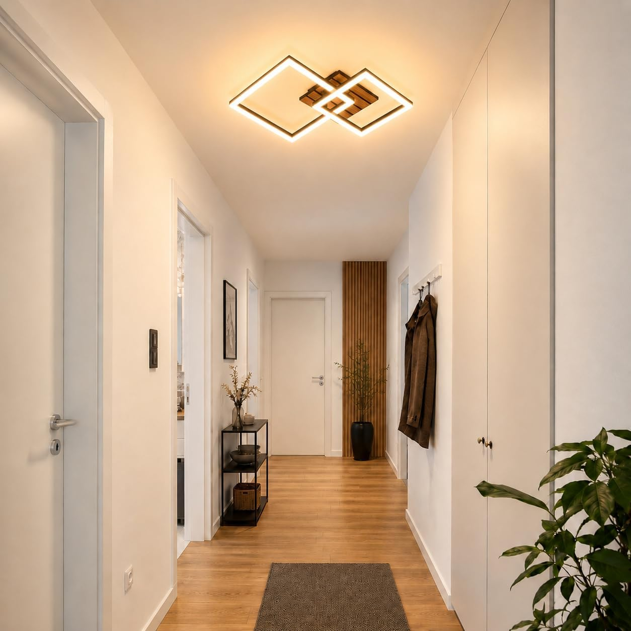 Ein Flur mit Holzboden, Türen, einem Kleiderständer und einer Deckenleuchte.