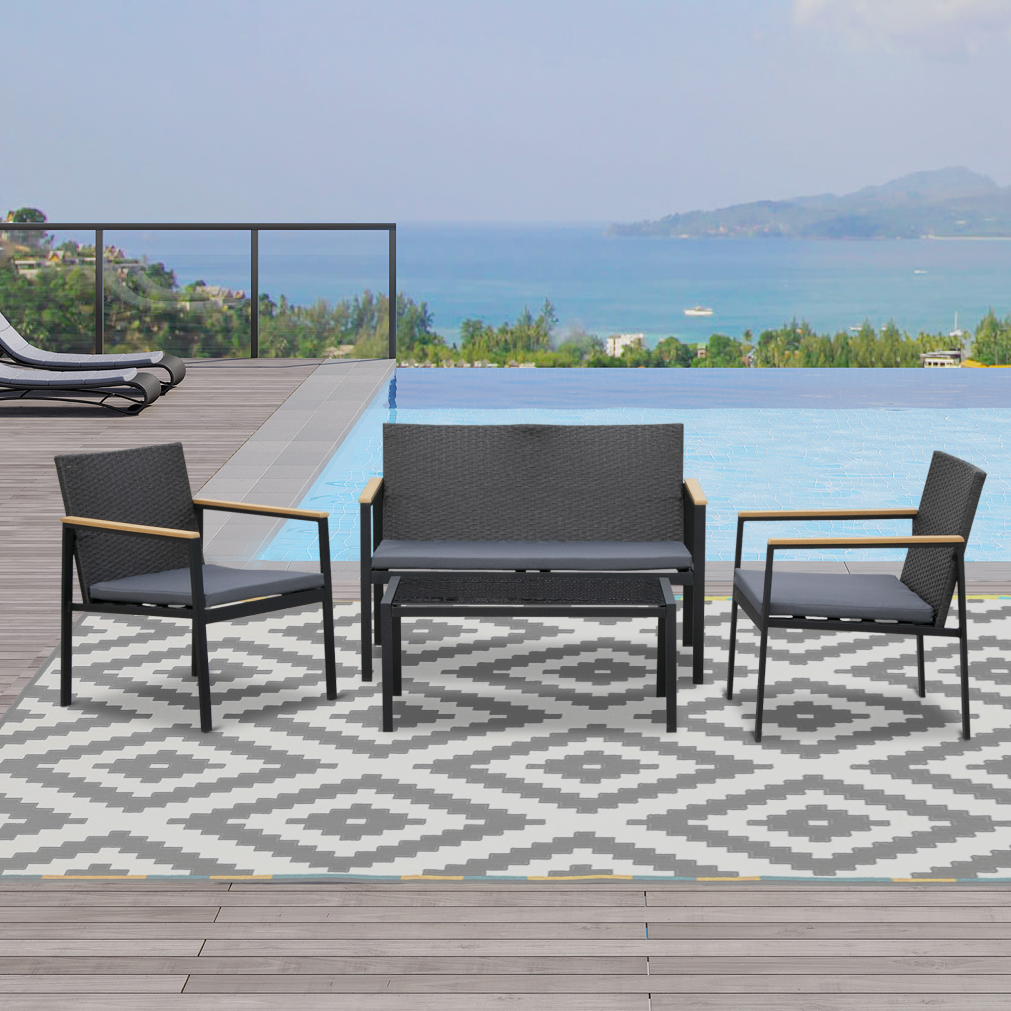 Set di mobili da esterno con sedie e panca su tappeto vicino piscina con vista mare.