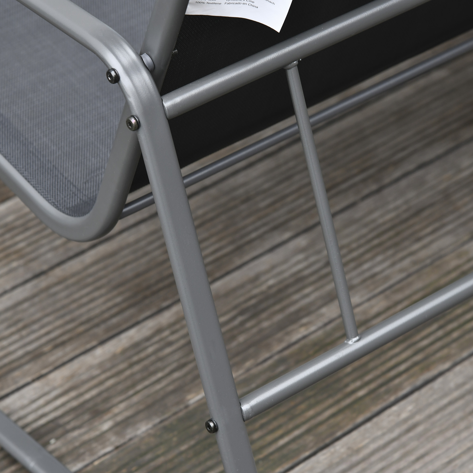 Telaio in metallo grigio di una sedia su assi di legno.