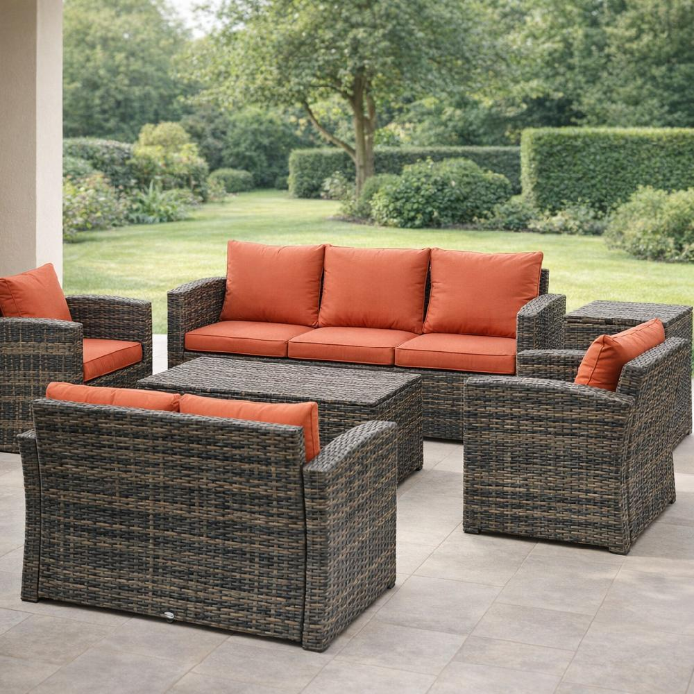 Mobili da esterno in rattan marrone scuro con cuscini arancioni su patio.