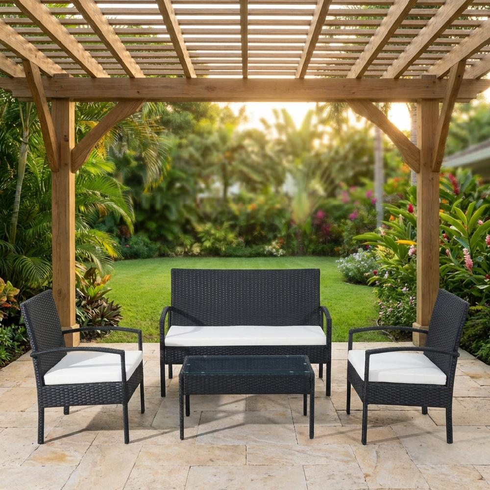 Un set di mobili in rattan nero con cuscini bianchi sotto una pergola in legno.