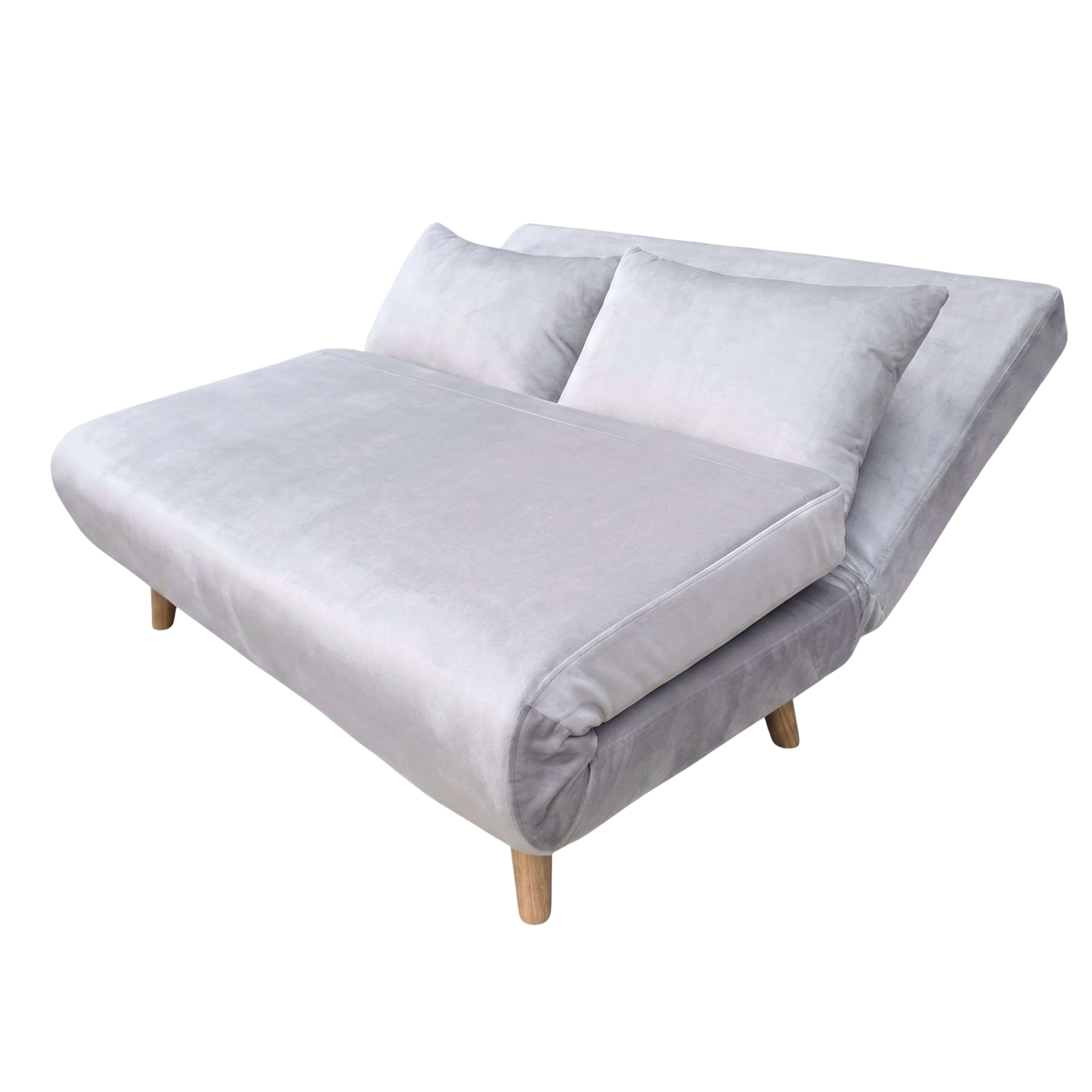 Un sofá cama gris claro con dos cojines y patas de madera.