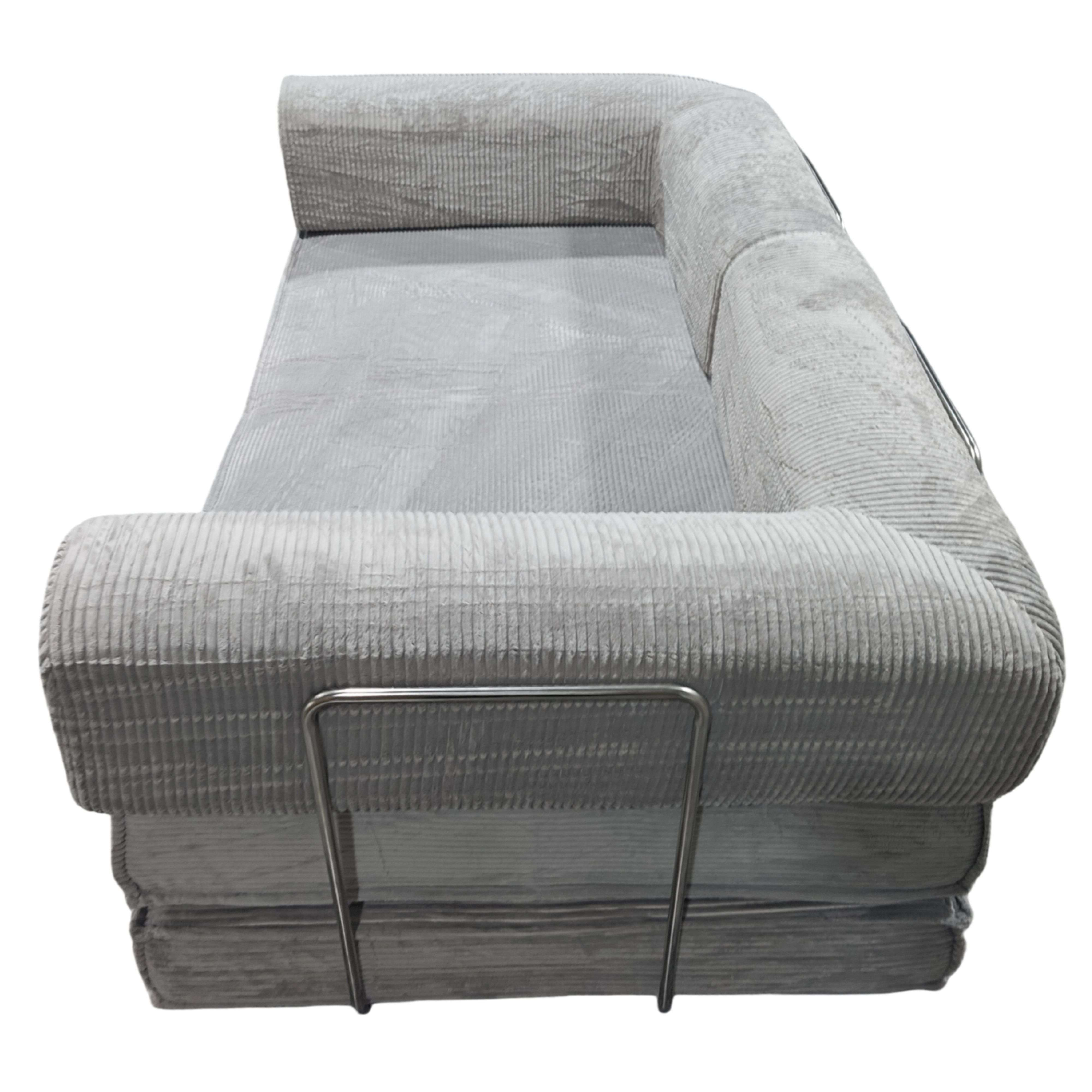 Sofá de pana gris con patas metálicas, sobre fondo blanco.