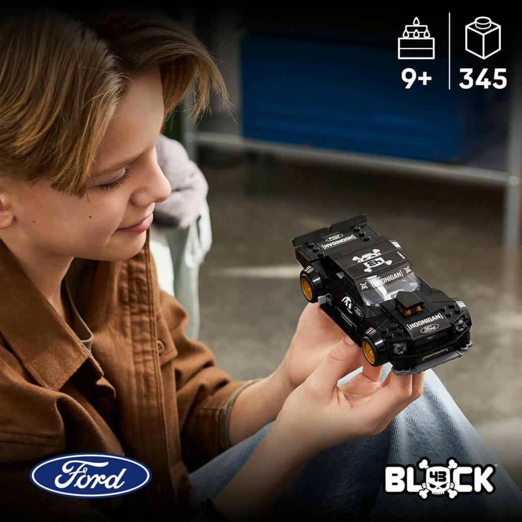 Chłopiec trzyma czarny samochód Lego Ford Mustang ze złotymi felgami.