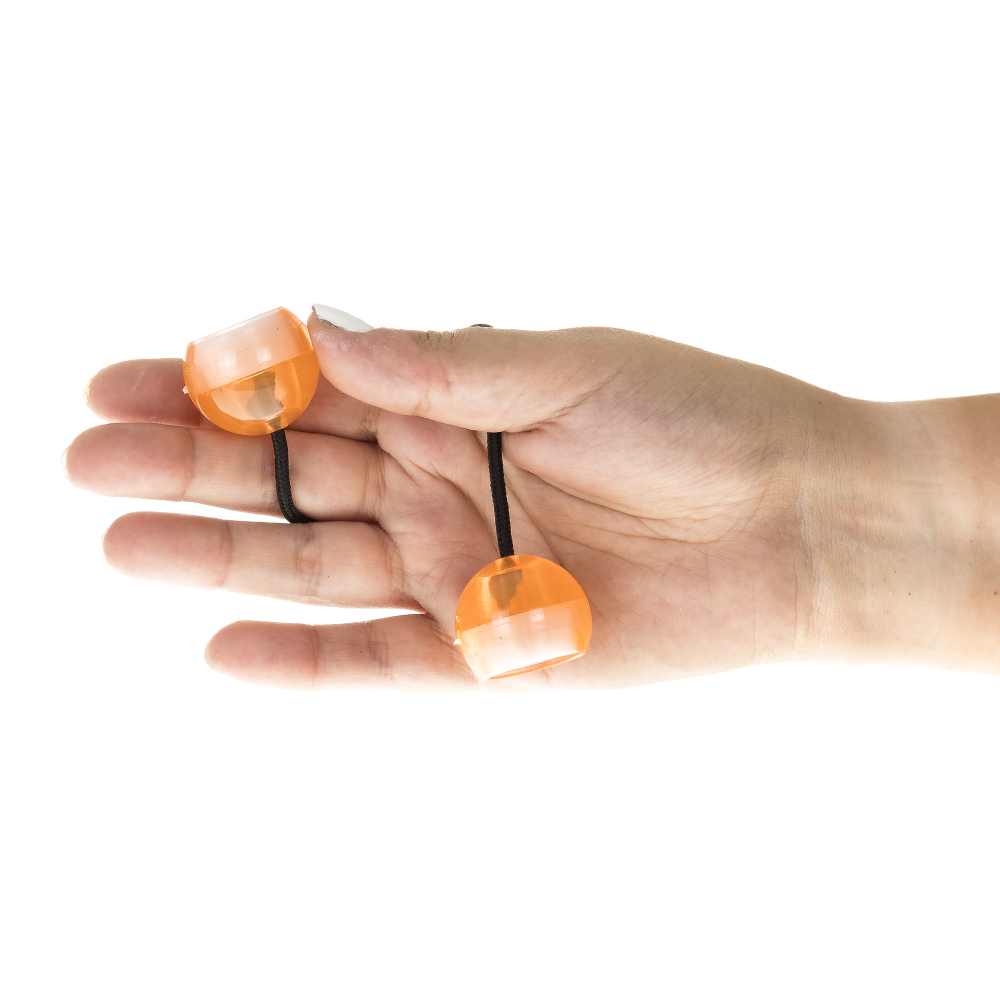 Una mano tiene due palline arancioni su corde attaccate a un elastico nero.