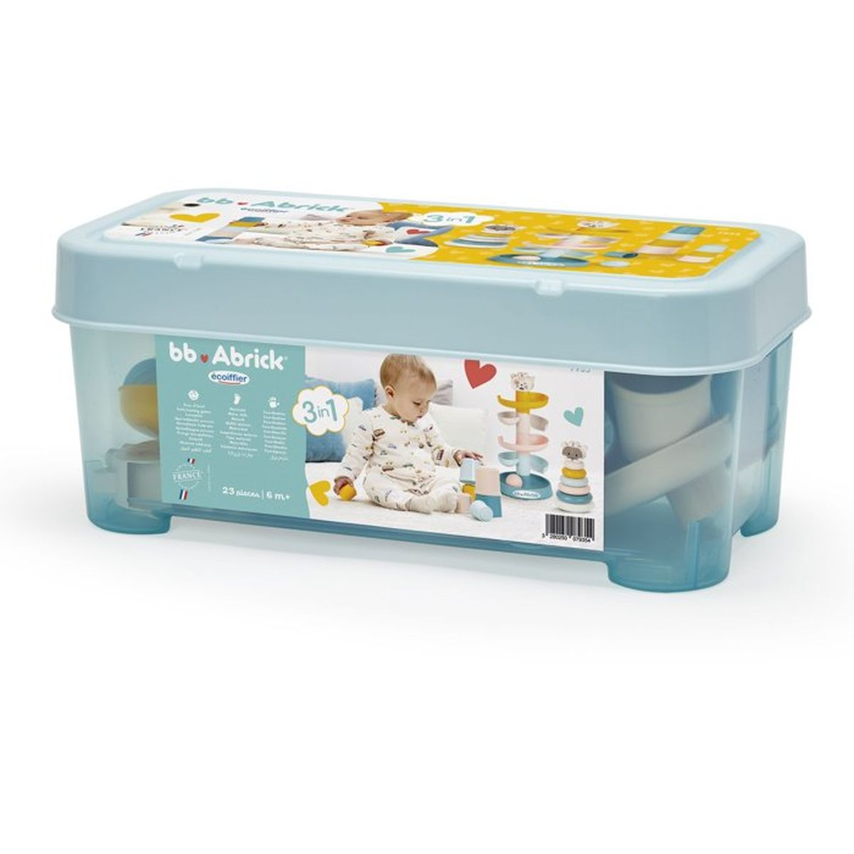 Bambino in pigiama gioca con giocattoli impilabili colorati in una scatola trasparente.