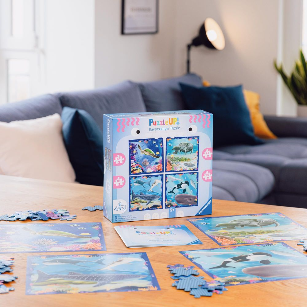 Ravensburger Puzzle-Box mit vier Meeresszenen. Puzzles auf dem Tisch ausgebreitet.