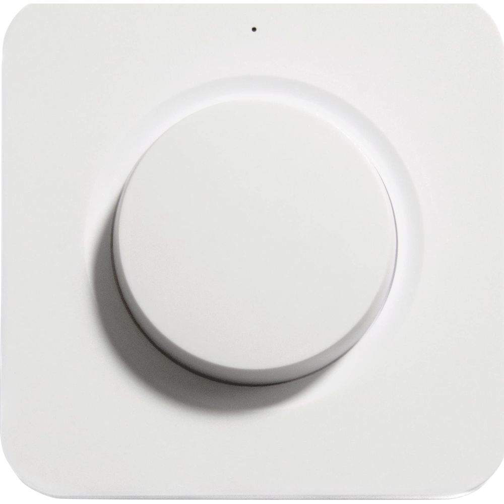 Ein weißer runder Knopf auf einem weißen quadratischen Gerät mit einem kleinen Punkt oben.