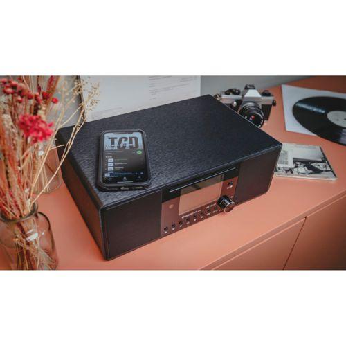 Giradischi nero con smartphone, fotocamera e disco accanto.