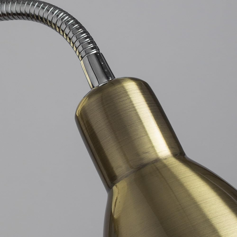 Nahaufnahme einer Messinglampe mit flexiblem Metallarm auf grauem Hintergrund.