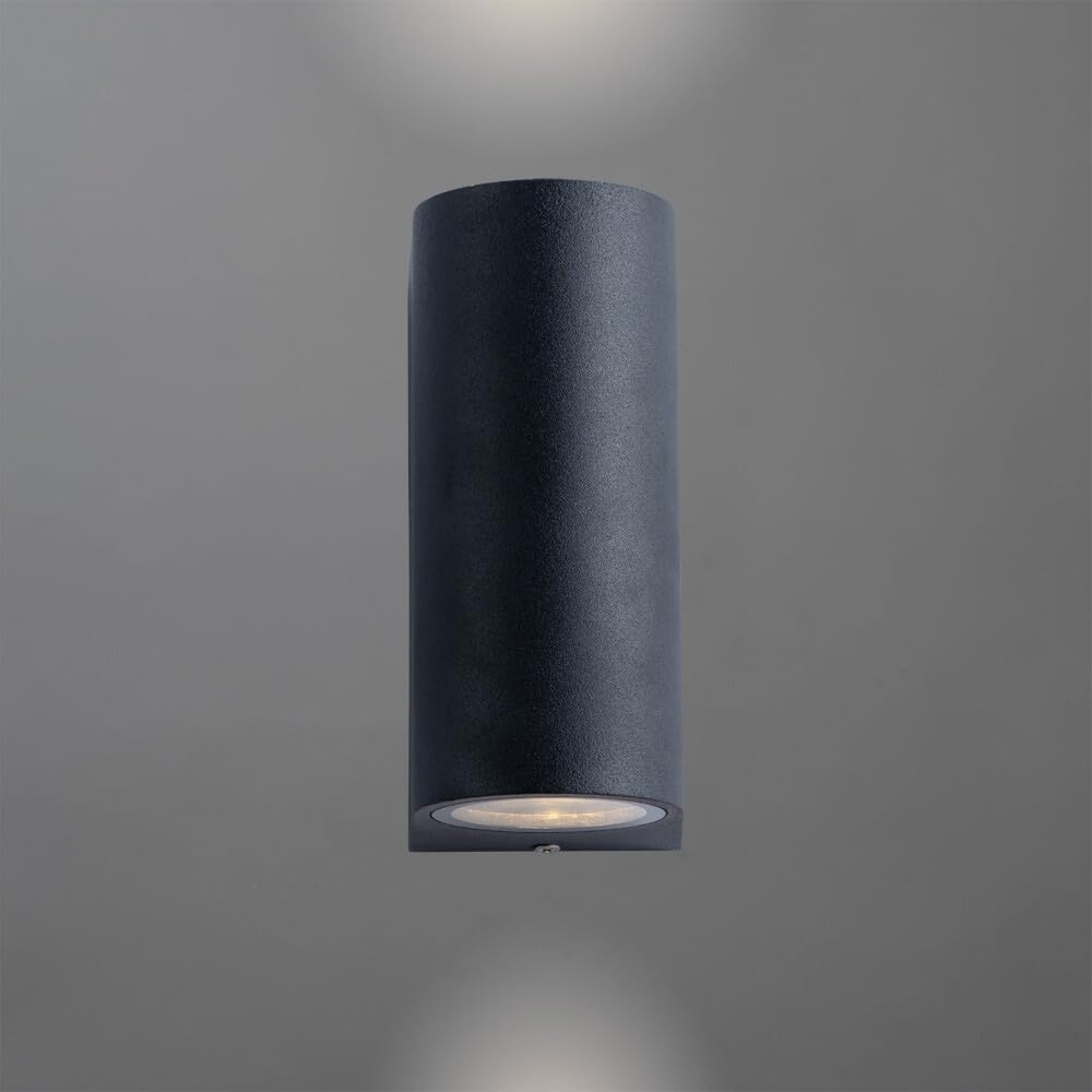 Eine dunkle, zylindrische Wandleuchte mit Licht nach oben und unten.