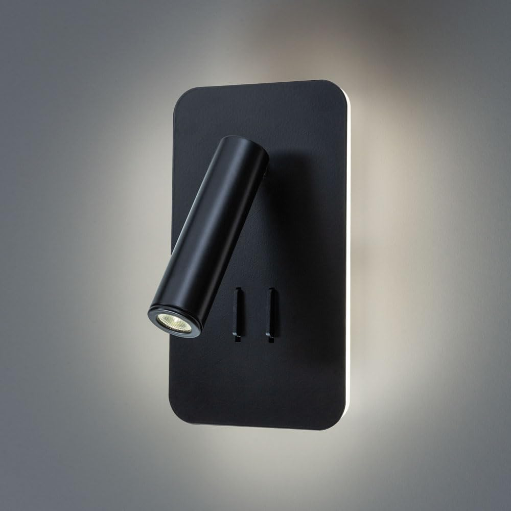 Ein schwarzer, zylindrischer Wandspot mit verstellbarem Kopf leuchtet auf einem schwarzen rechteckigen Sockel.